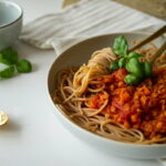 Teller mit veganer Linsenbolognese auf dem Esstisch